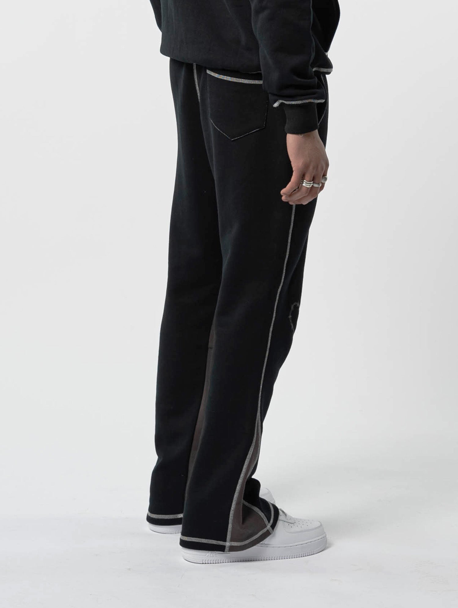 Model back view of kortsiide Superstar Stitched Flared Triple Black Sweatpants